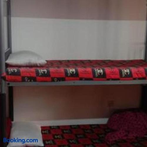 a bunk bed with a red and white blanket on it at Making friends with guests in Sharjah