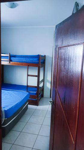 Cette chambre comprend 2 lits superposés et une porte. dans l'établissement Casa - Temporada, à Praia Grande