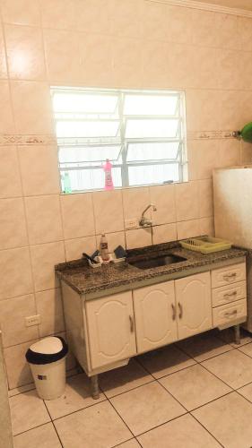 une cuisine avec un évier et une fenêtre dans l'établissement Casa - Temporada, à Praia Grande
