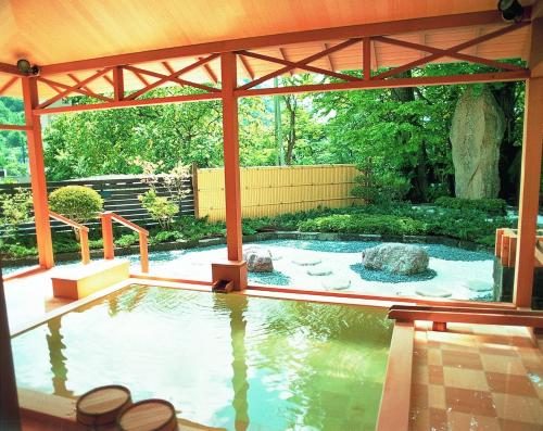a swimming pool in a garden with a pavilion at Jozankei Daiichi Hotel Suizantei in Jozankei