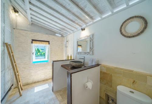 a bathroom with a toilet and a sink at Ora Villas Gili Meno in Gili Meno