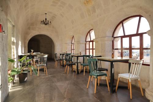 - un restaurant avec des tables et des chaises dans une salle dotée de fenêtres dans l'établissement Estancia El Solar, à Arequipa