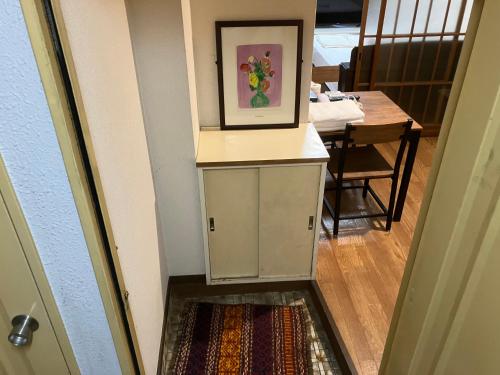 a hallway with a table and a picture on the wall at Casa Viento Stay Inn in Hiroshima