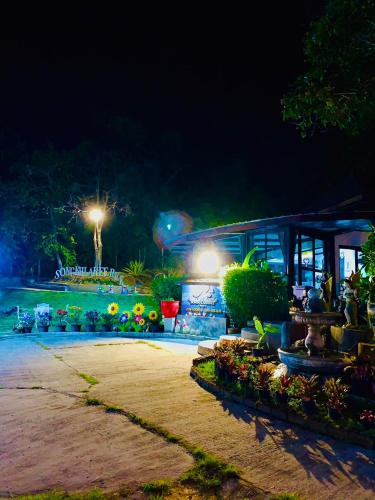 a garden at night with flowers and a building at สงขลาคีรี รีสอร์ท SongkhlaKeeree Resort in Ban Khao Rup Chang