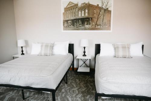two beds in a room with a picture on the wall at Bricktown Inn in Camp Point