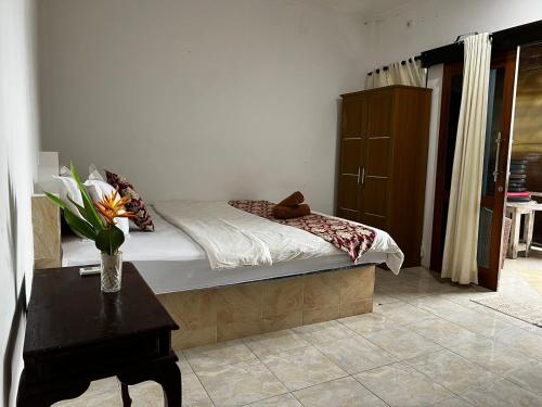 a bedroom with a bed with a table and a dresser at Tarci Bungalows Lembongan in Nusa Lembongan