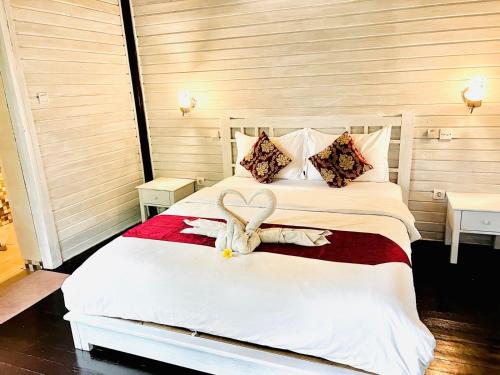 a bedroom with a bed with a stuffed animal on it at Tarci Bungalows Lembongan in Nusa Lembongan