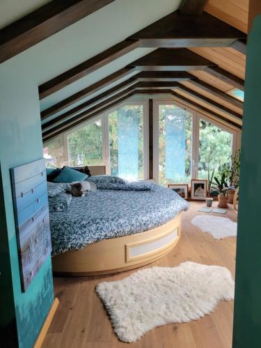 een slaapkamer met een bed in een kamer met ramen bij Südländische Flair in Neubiberg