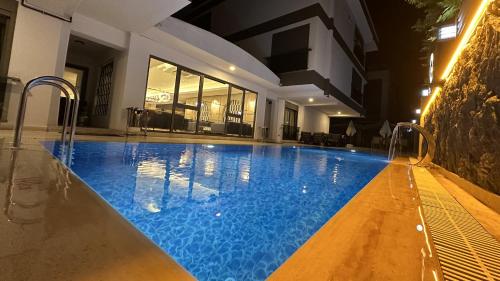 a large swimming pool with blue water in a building at Quality Gold Suite Hotel in Antalya