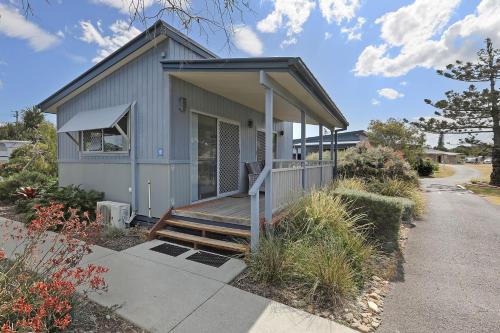 a small house with a porch and a deck at Reflections Lennox Head - Holiday Park in Lennox Head