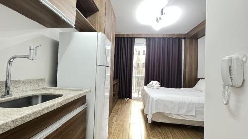 Il comprend une cuisine avec un évier et une chambre avec un lit. dans l'établissement MH 20206 - Lindo Studio com AC/Wi-Fi/Cama Queen, à São Paulo
