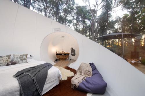 Un dormitorio con una cama grande y una habitación redonda. en Skyview Bubbletent, en Eganstown