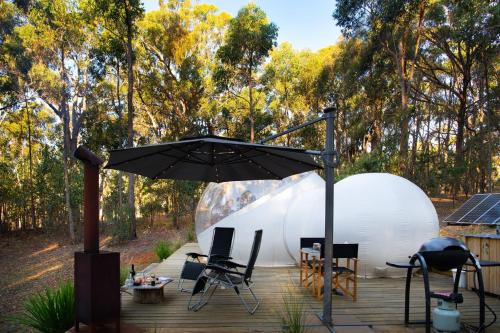una tienda de campaña en una terraza con una sombrilla en Skyview Bubbletent, en Eganstown