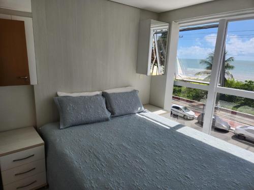Säng eller sängar i ett rum på Lindíssimo Flat Atlântico Sul no Cabo Branco com vista para o mar em JP
