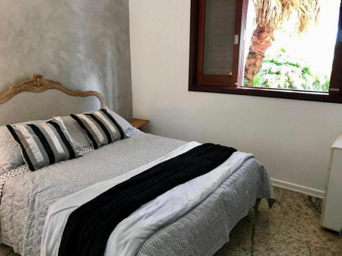 a bed in a bedroom with a window at Loft em chácara Espírito Santo in Espirito Santo Do Pinhal