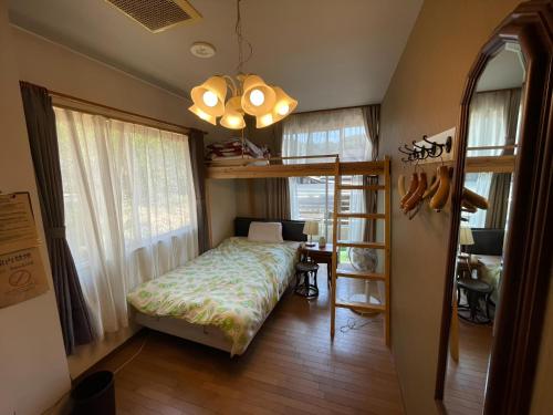 a bedroom with a bunk bed and a desk at まちやど　Motomachi in Daigo