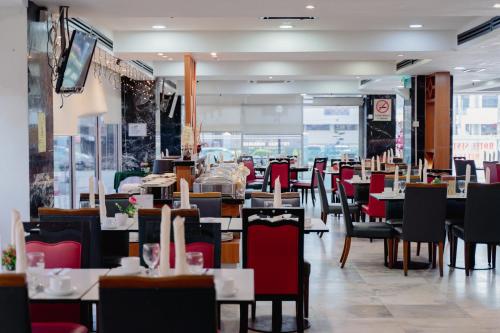 Hotel Sentral Melaka @ City Centre في ميلاكا: غرفة طعام مع طاولات وكراسي في مطعم