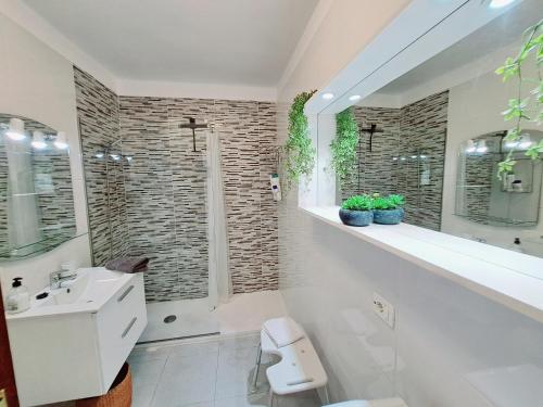 a white bathroom with a sink and a shower at Estrella del Mar in El Médano