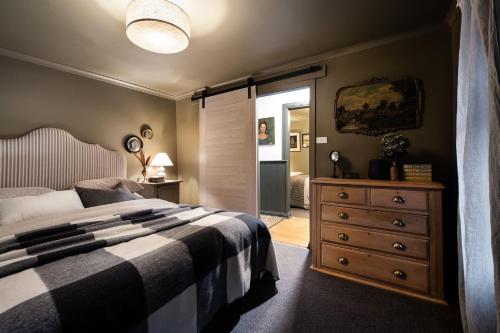a bedroom with a bed and a dresser with a mirror at Innisfree in Daylesford
