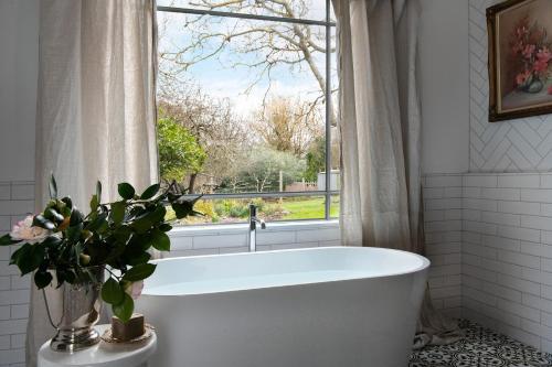a white bath tub in a bathroom with a window at Innisfree in Daylesford