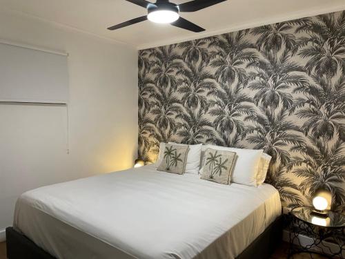 - une chambre avec un grand lit et du papier peint dans l'établissement Il Palazzo Holiday Apartments, à Cairns