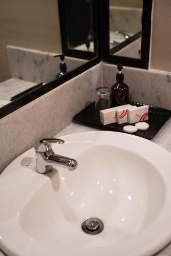 a white sink in a bathroom with a mirror at Hotel Sentral Melaka @ City Centre in Melaka