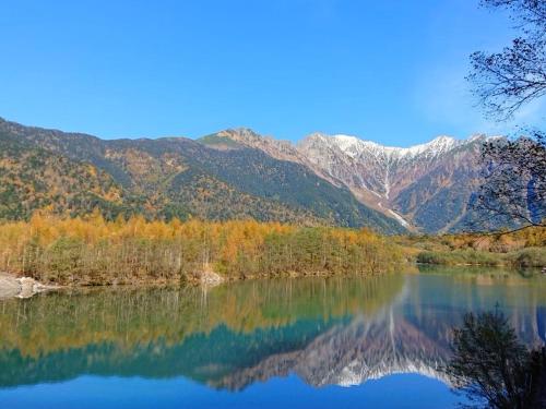 a view of a lake with mountains in the background at Yamano Hidaya in Matsumoto