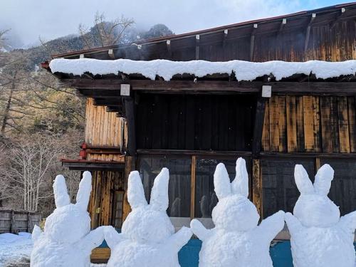 a group of snow bunnies standing in front of a building at Yamano Hidaya in Matsumoto