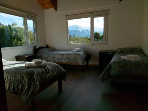 Habitación con 2 camas y 2 ventanas. en Casa Cerro Ventana Bariloche 2 en San Carlos de Bariloche
