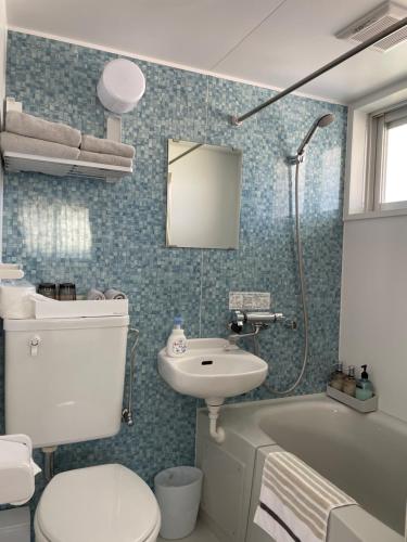 ein Badezimmer mit einem WC, einem Waschbecken und einer Badewanne in der Unterkunft Dining & Stay 38 Miyahira in Zamami