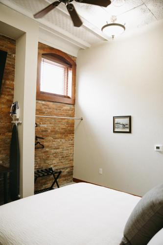 a bedroom with a bed and a brick wall at Bricktown Inn in Camp Point