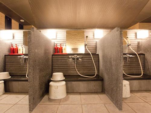 a public bathroom with two sinks and two showers at Sansuien in Kochi