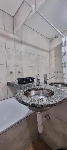 a bathroom with two sinks and a granite counter top at JUJUY SOHO in San Salvador de Jujuy