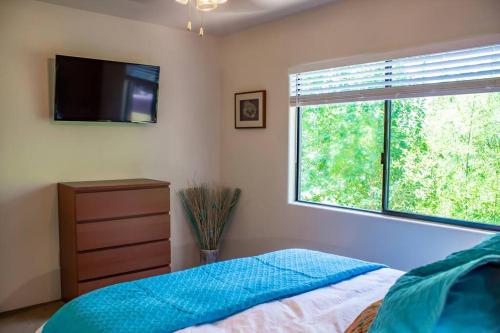 1 dormitorio con 1 cama, TV y ventana en Carnelian Coyote - Fabulous Condo in West Sedona! en Sedona