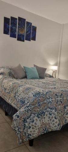 a bed in a bedroom with pictures on the wall at JUJUY SOHO in San Salvador de Jujuy
