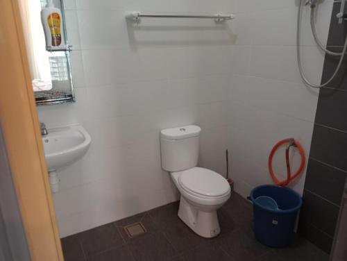 a white bathroom with a toilet and a sink at Amara Homestay Kuantan in Kampong Bugis