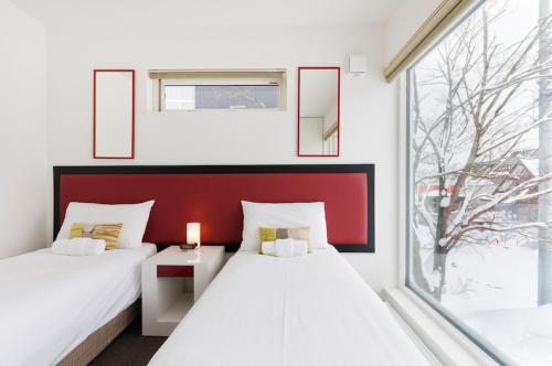 two beds in a room with a window at Seisei in Kutchan