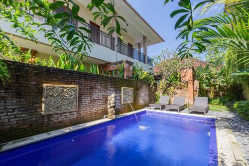 a swimming pool in front of a house at Komala Homestay in Canggu