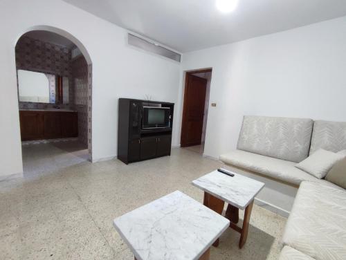 a living room with a couch and a tv at Calm place and near to the beach in Monastir