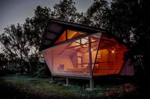 a glass house in the middle of a field at Bamurru Plains in Point Stuart