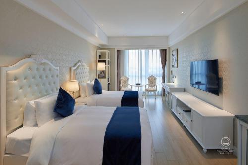 um quarto de hotel com duas camas e uma televisão de ecrã plano em GUOCE International Convention & Exhibition Center em Shunyi