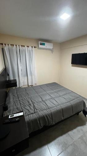 Schlafzimmer mit einem Bett, einem Schreibtisch und einem Fenster in der Unterkunft Las Rejas Departamento in San Fernando del Valle de Catamarca