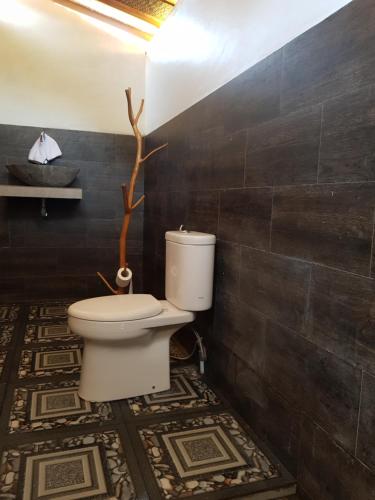uma casa de banho com um WC numa parede preta em Pondok Bali Volcano em Kubupenlokan