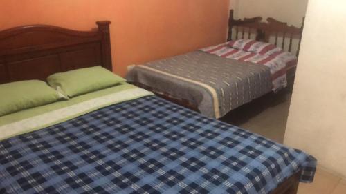 two beds in a small room with at Pensión Malacatos in Loja