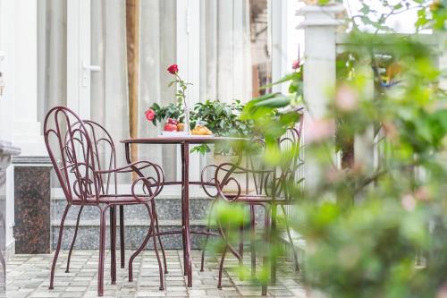 einen Tisch und Stühle auf einer Terrasse mit Blumen in der Unterkunft Villa Hoa Ly Đà Lạt in Da Lat