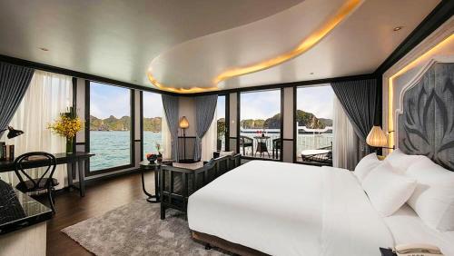 a bedroom with a large white bed with a view of the water at Lotus Elegance Cruise in Ha Long