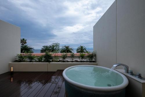 a bath tub in a bathroom with a view of the ocean at MARISSA RESORT sazanseto suo-oshima in Suo Oshima