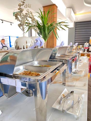 a row of buffet tables with food on them at KunKin Garden Aparthotel in Ho Chi Minh City