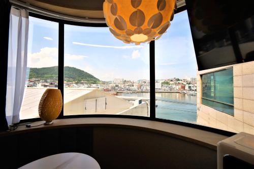 a room with a window with a view of the water at De Lamour Hotel in Tongyeong