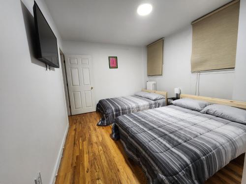 a bedroom with two beds and a flat screen tv at Spacious 3 bedroom apartment mins to NYC! in Union City